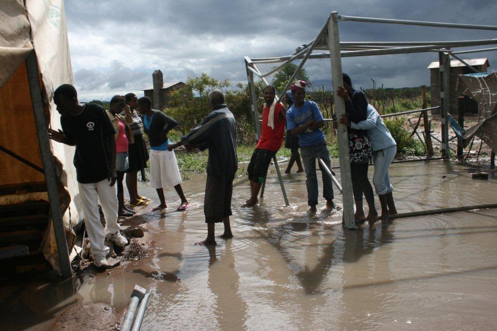 Mazwi villagers entering the water logged tent for the love of puppetry show